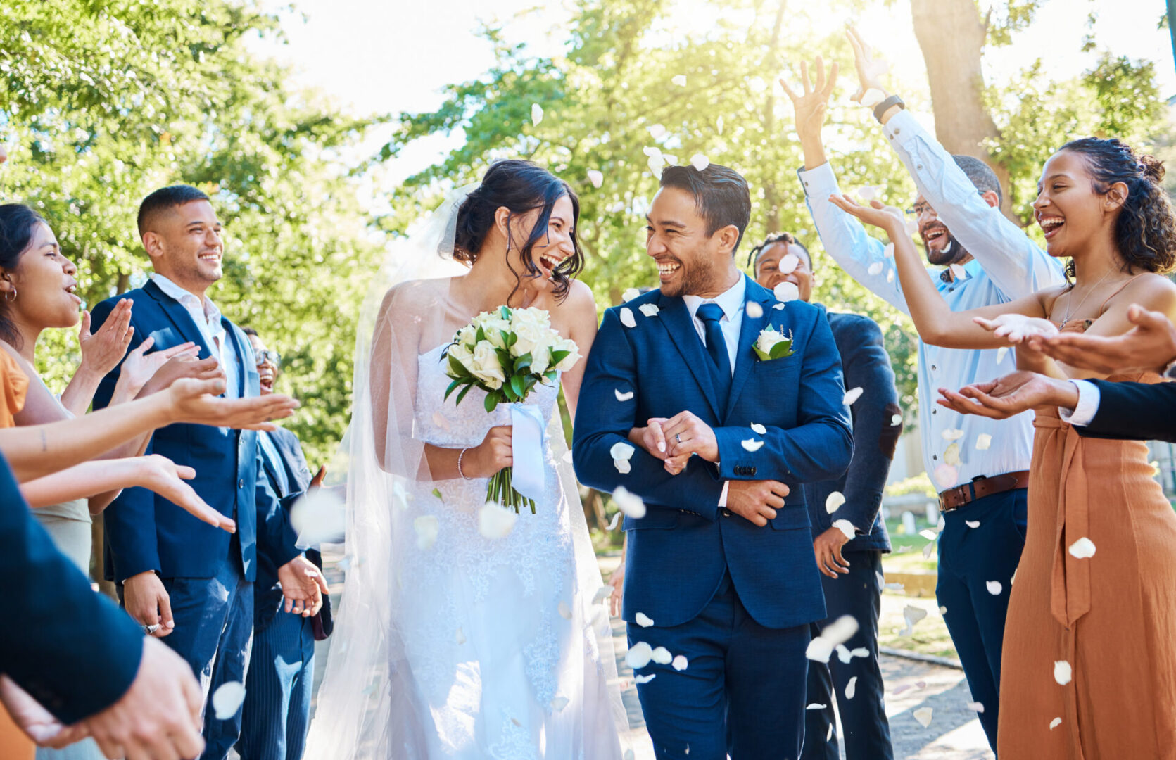 Bride and groom celebrating with guests outdoors.