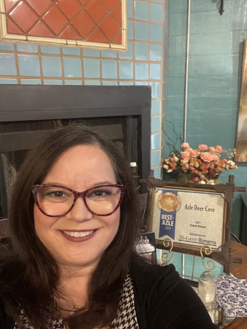 Smiling woman in glasses with award display.