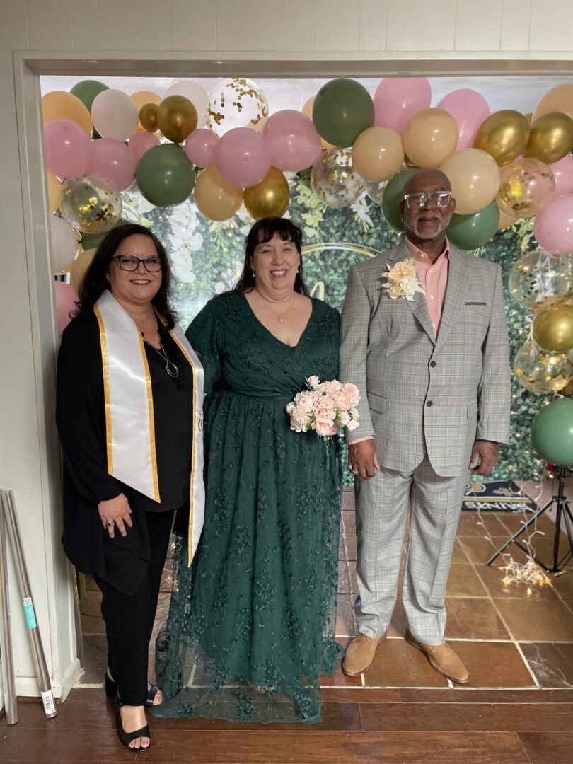 Three people posing at a celebration.