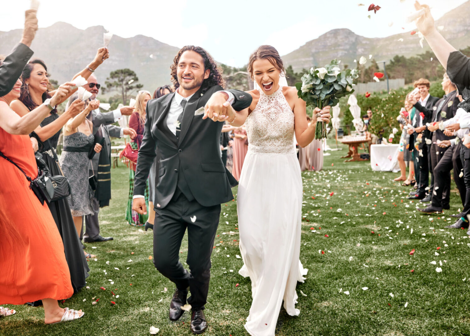 Bride and groom celebrating outdoor wedding ceremony.